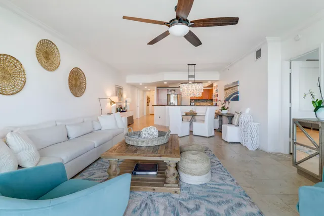 a living room with furniture kitchen view and a chandelier