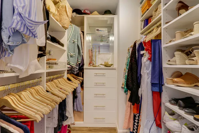 a view of walk in closet with clothes and shoes