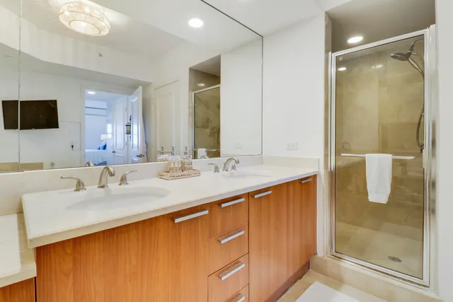 a bathroom with a double vanity sink mirror and shower