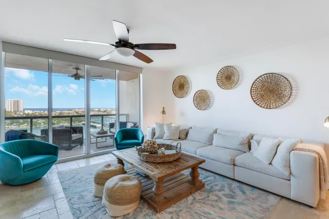 a living room with furniture kitchen view and a large window