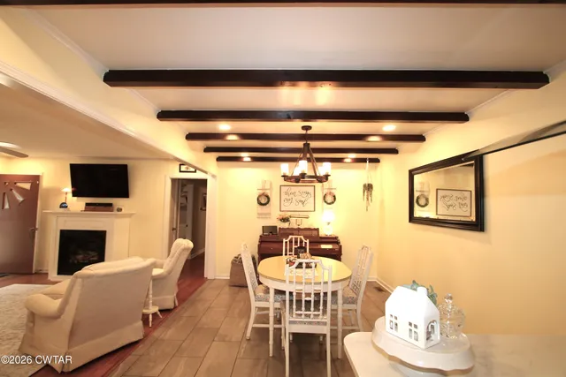 a dining room with furniture a fireplace and a flat screen tv