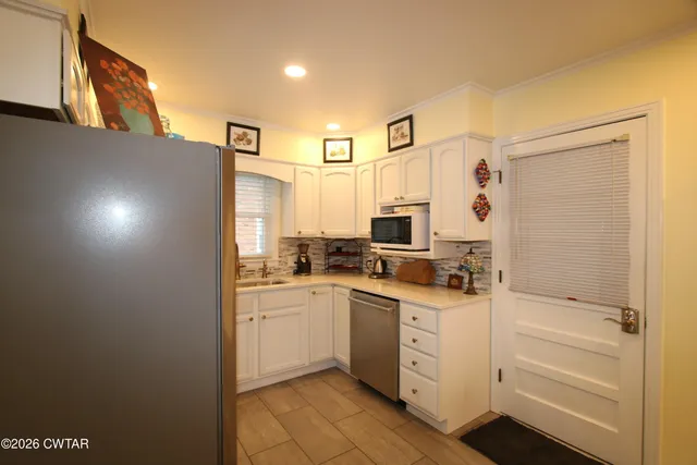 a kitchen with a sink cabinets stainless steel appliances and a window