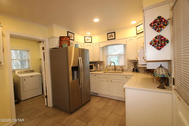 a kitchen with a refrigerator a stove top oven and a sink