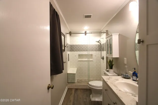 a bathroom with a sink a toilet and shower