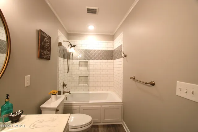 a bathroom with a bathtub shower sink mirror vanity and toilet