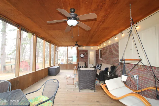 a living room with furniture ceiling fan and a large window