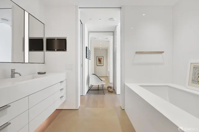 a bathroom with a tub sink and mirror