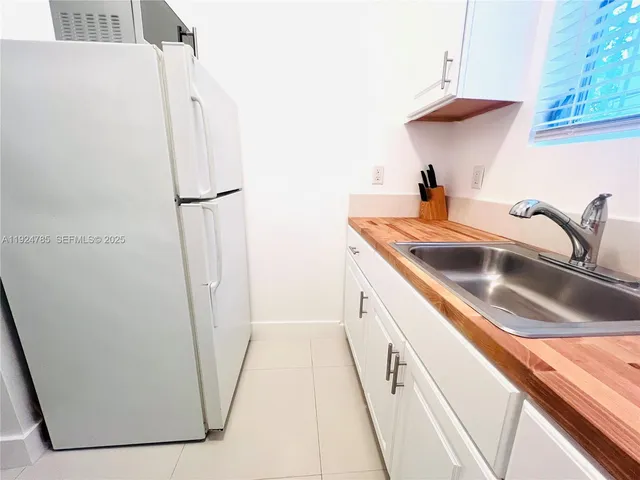 a view of a kitchen sink and a refrigerator