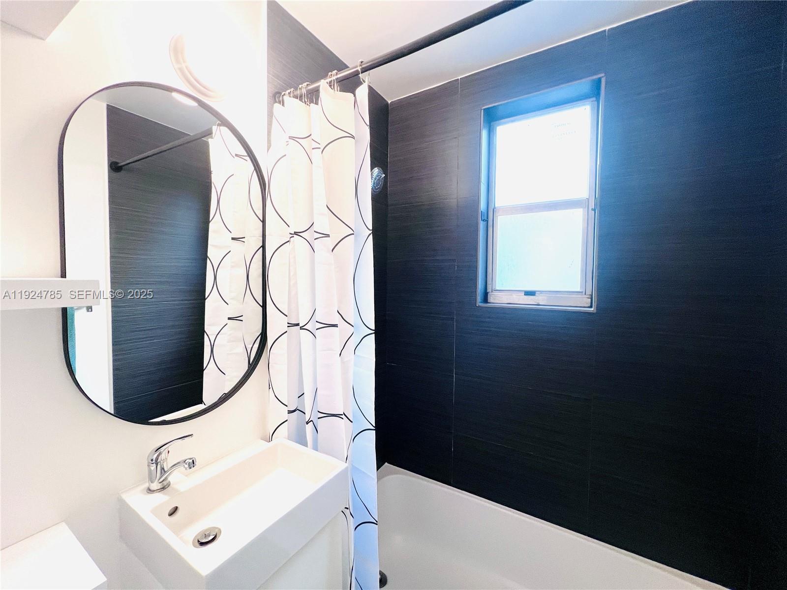 1525 Meridian Avenue, Unit 110 Miami Beach, FL 33139 - Photo 14 of 23 a bathroom with a sink a vanity and a mirror