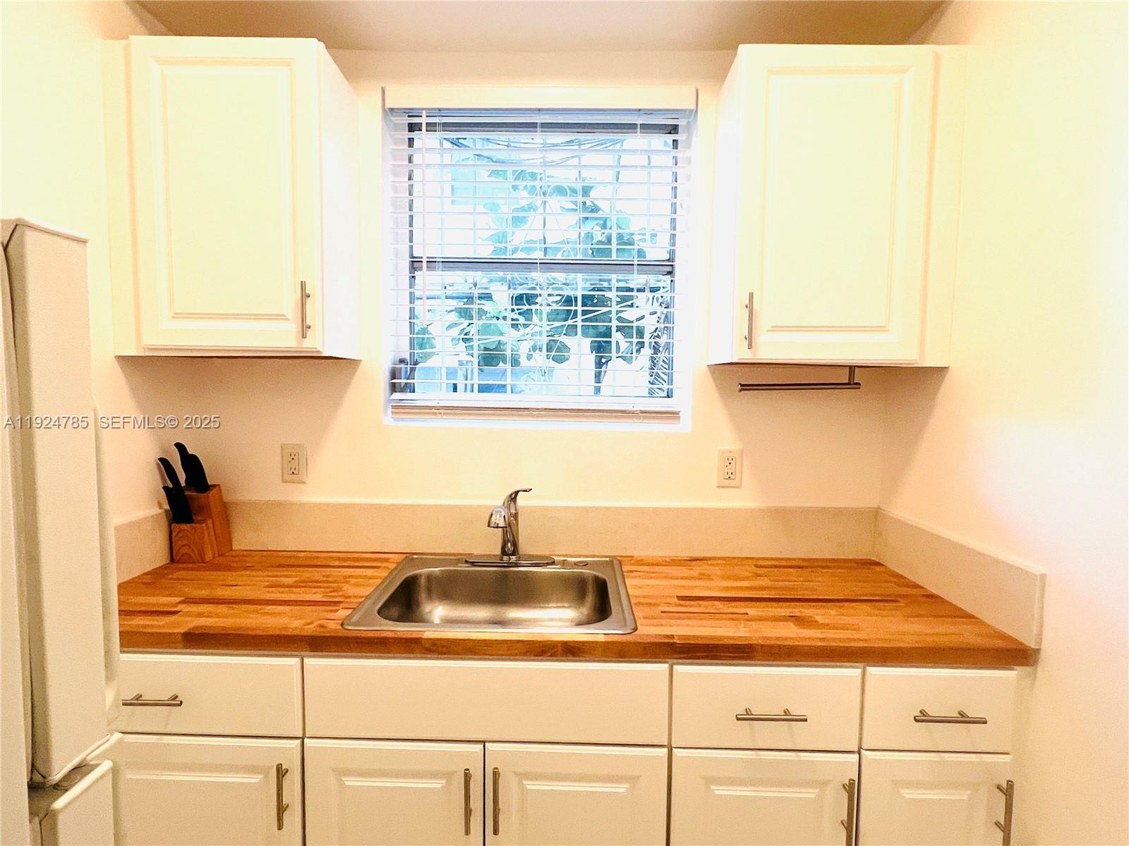 1525 Meridian Avenue, Unit 110 Miami Beach, FL 33139 - Photo 4 of 23 a kitchen with a sink cabinets and window