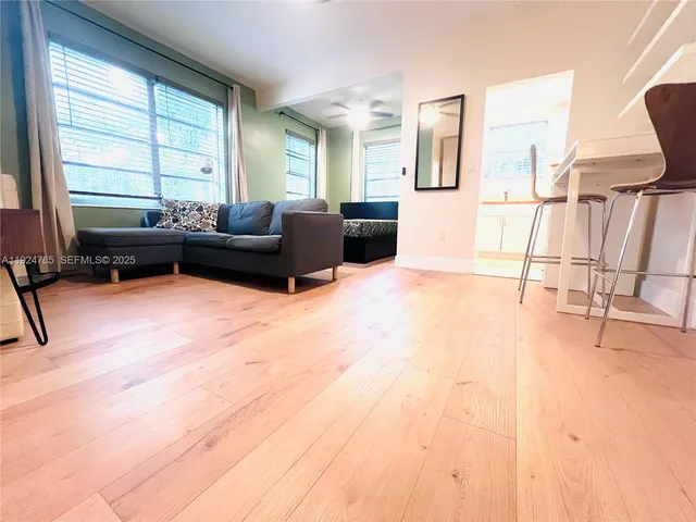 a living room with furniture a flat screen tv and a window