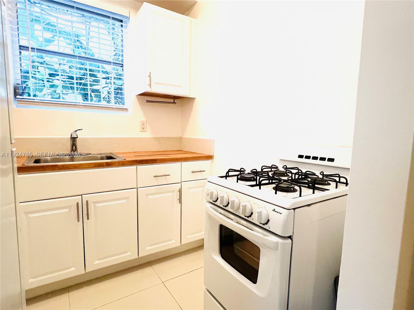1525 Meridian Avenue, Unit 110 Miami Beach, FL 33139 - Photo 10 of 23 a white stove top oven sitting inside of a kitchen