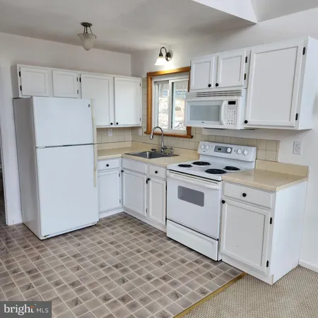 a view of a house with a yard and wooden fence