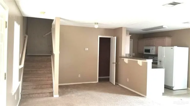 a view of a kitchen with refrigerator and a sink