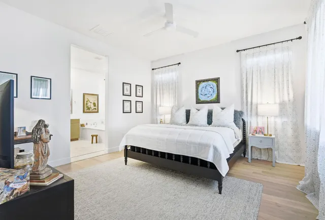 a spacious bedroom with a bed and a dresser