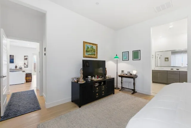 a living room with furniture a flat screen tv and kitchen view