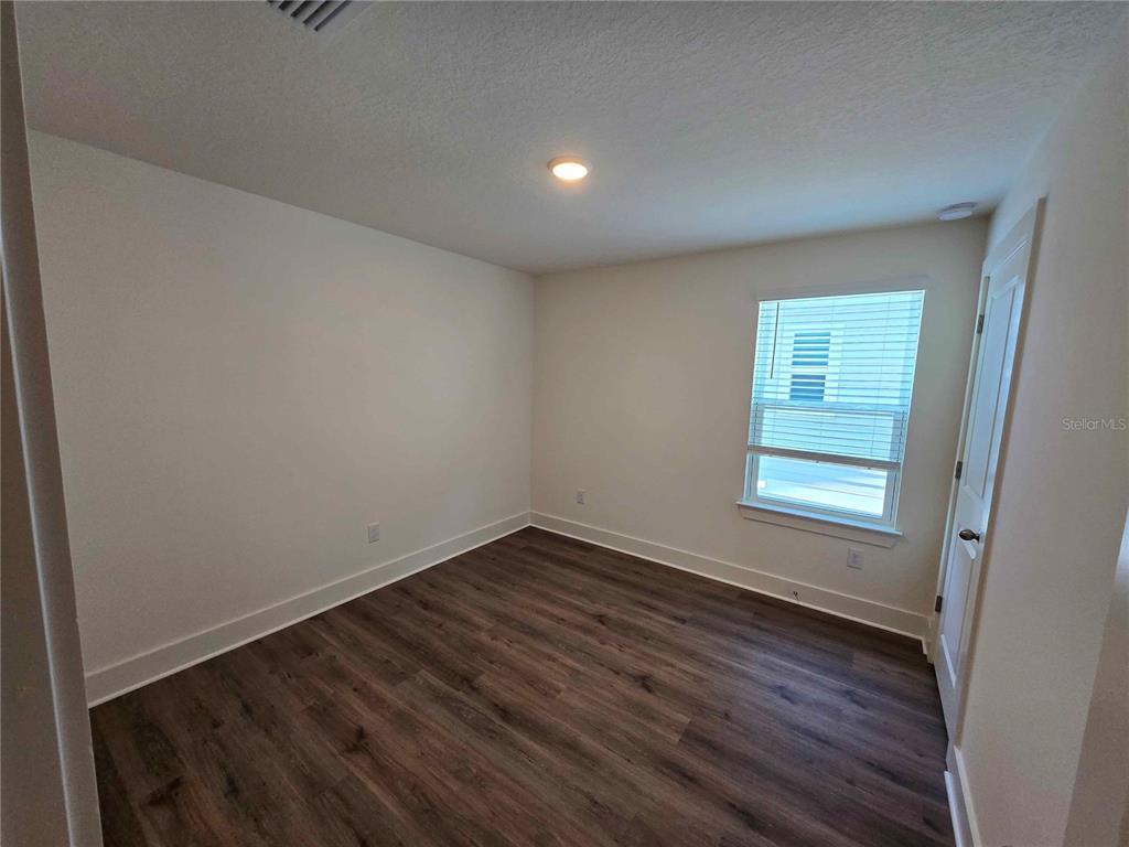 3819 Daybreak Run Loop Spring Hill, FL 34609 - Photo 15 of 15 an empty room with wooden floor and windows