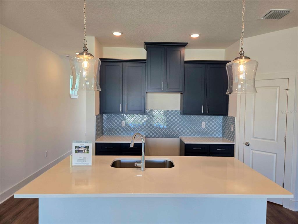 3819 Daybreak Run Loop Spring Hill, FL 34609 - Photo 3 of 15 a kitchen with kitchen island a sink stainless steel appliances and cabinets