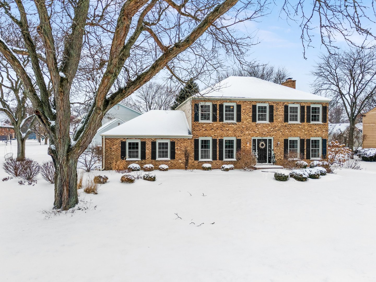 a front view of a building with cars parked