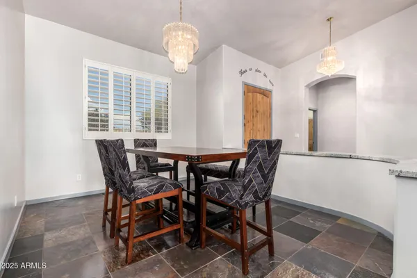 a kitchen with a refrigerator a stove a sink and a dining table with wooden floor