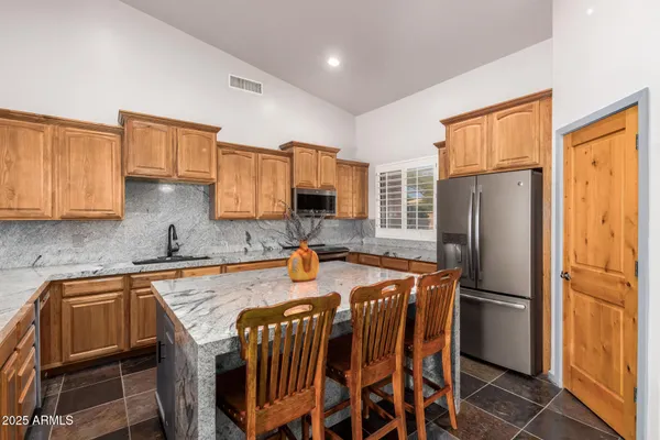 a kitchen with stainless steel appliances granite countertop a sink a stove and a granite counter tops with a window