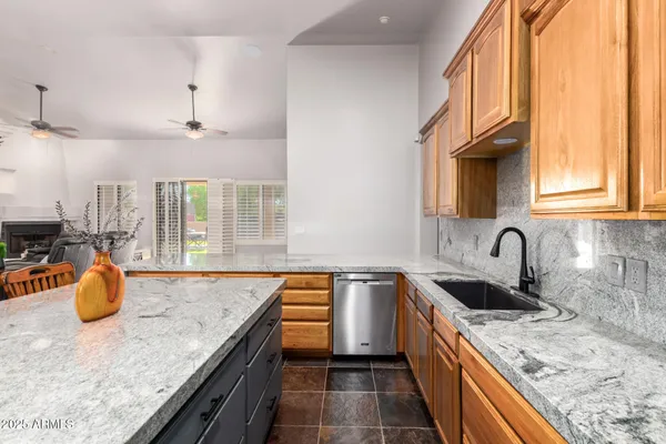 a kitchen with stainless steel appliances granite countertop a sink and a refrigerator