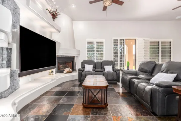 a living room with furniture a flat screen tv and a fireplace