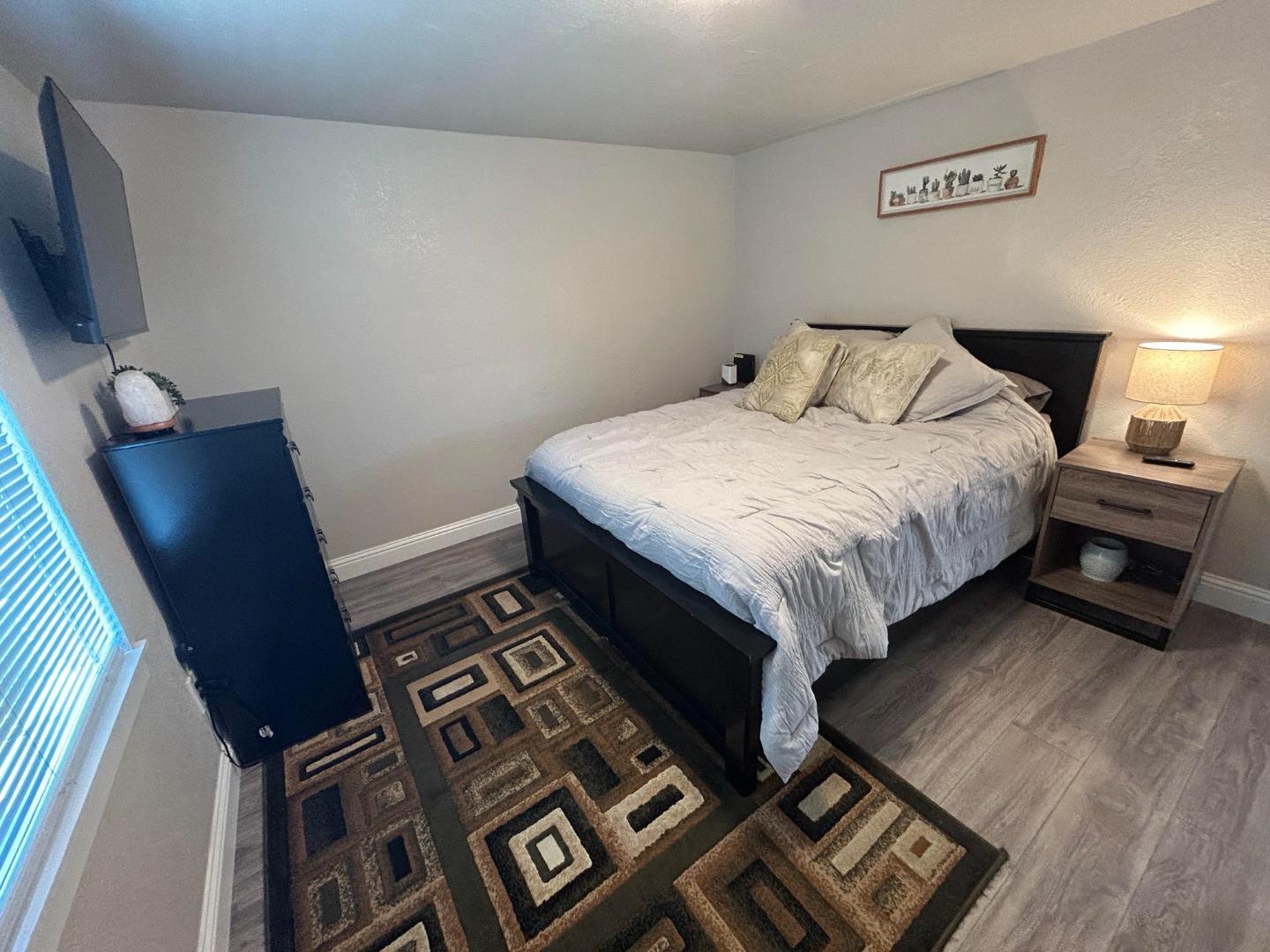 756 1st Street Gilroy, CA 95020 - Photo 11 of 14 a bedroom with a bed and a flat tv screen on a dresser