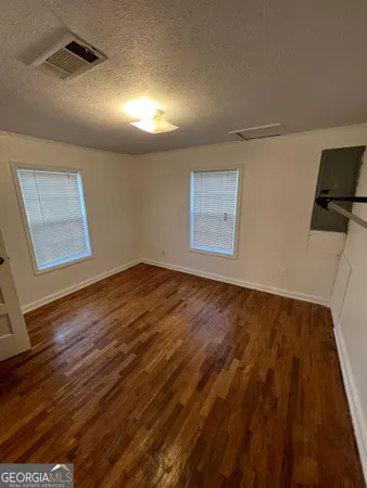 a view of empty room with wooden floor
