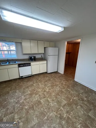 a large kitchen with a stove refrigerator sink and cabinets