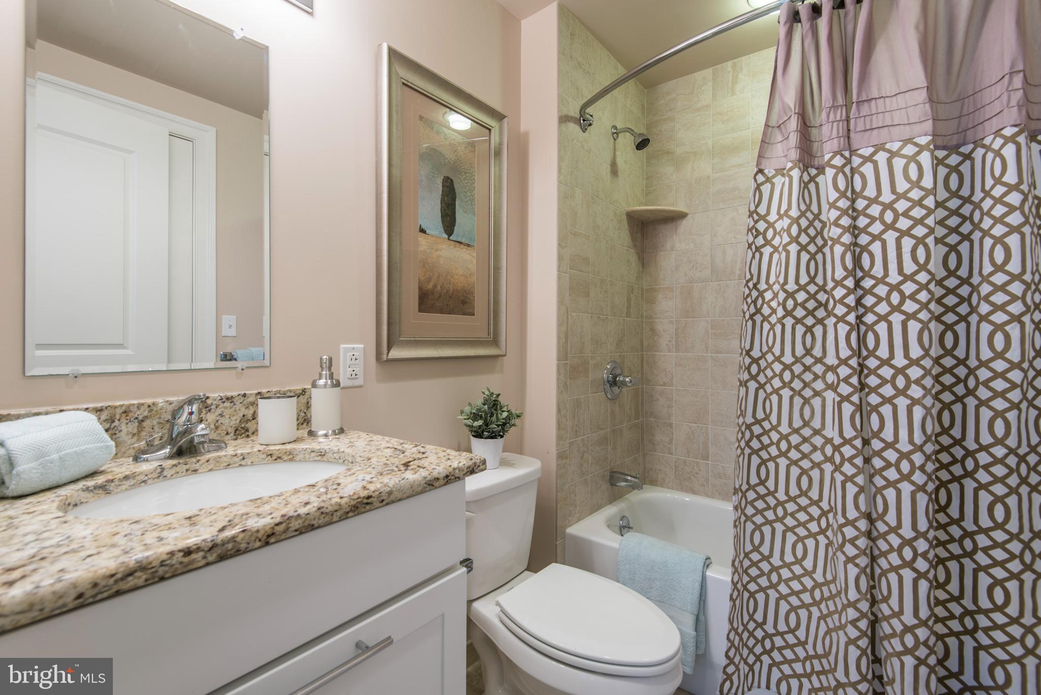1501 Locust Street, Unit 403 Philadelphia, PA 19102 - Photo 18 of 23 a bathroom with a granite countertop sink toilet and shower