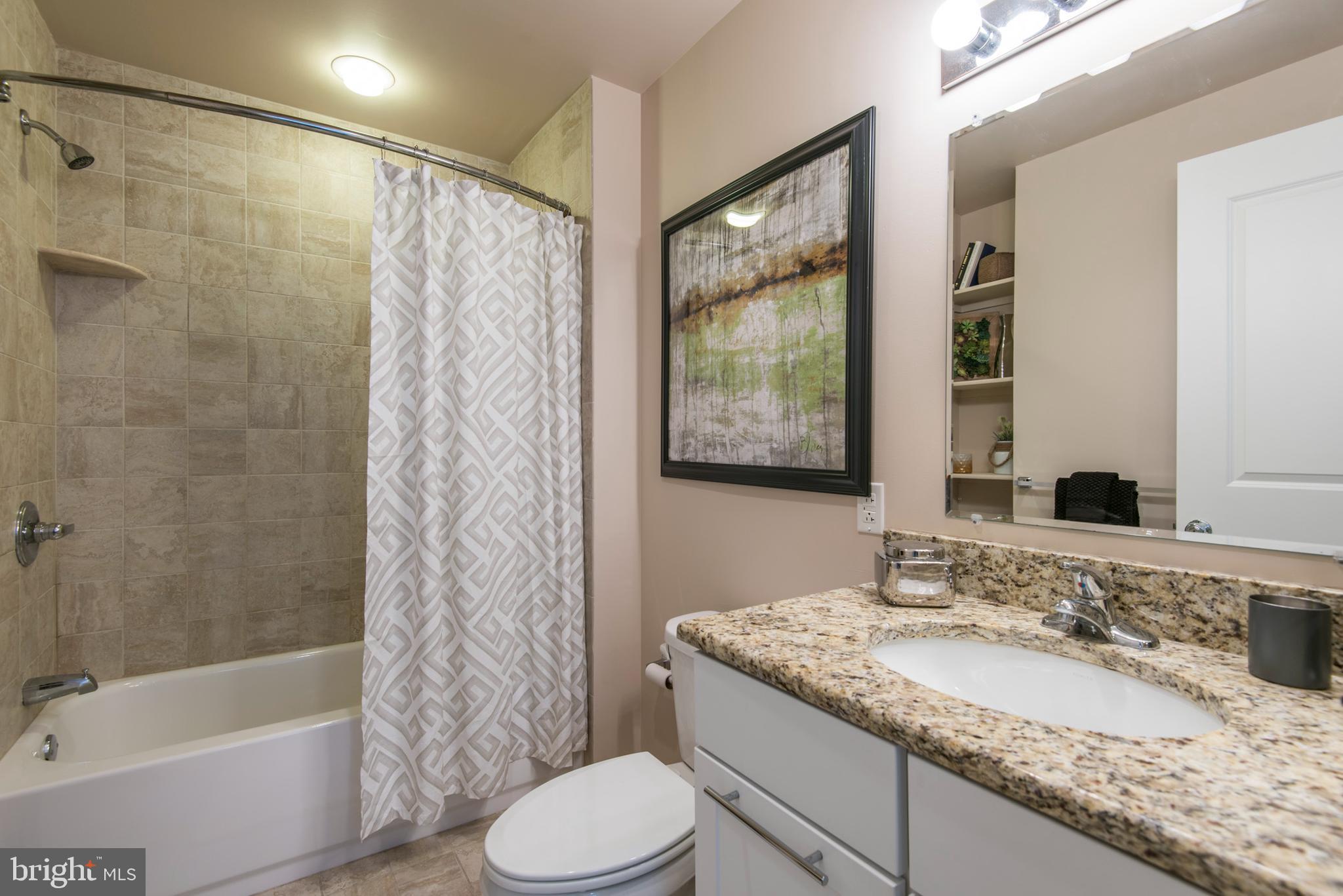 1501 Locust Street, Unit 403 Philadelphia, PA 19102 - Photo 21 of 23 a bathroom with a granite countertop sink toilet and shower