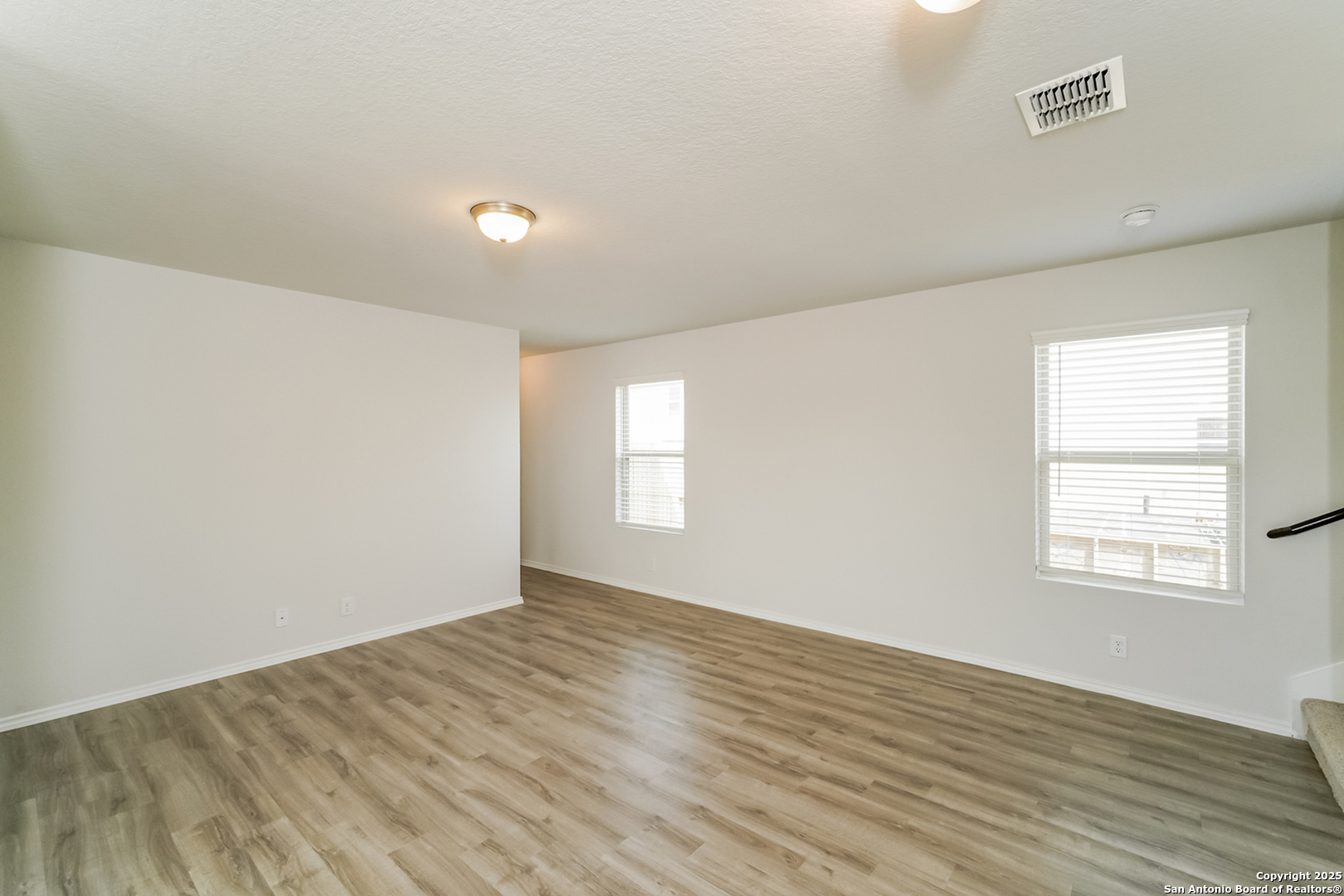 5018 Blue Ranch San Antonio, TX 78222 - Photo 6 of 17 an empty room with wooden floor and windows