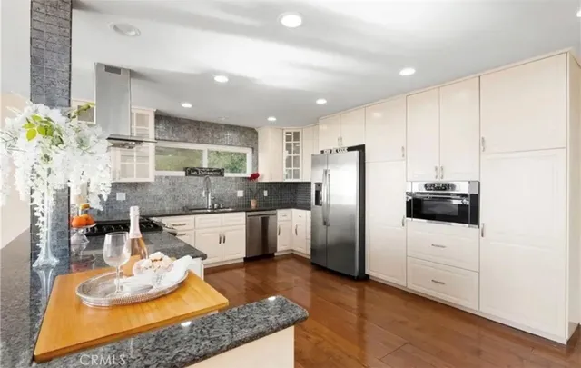 a kitchen with stainless steel appliances granite countertop a sink refrigerator and microwave