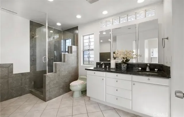a bathroom with a double vanity sink a toilet and a mirror