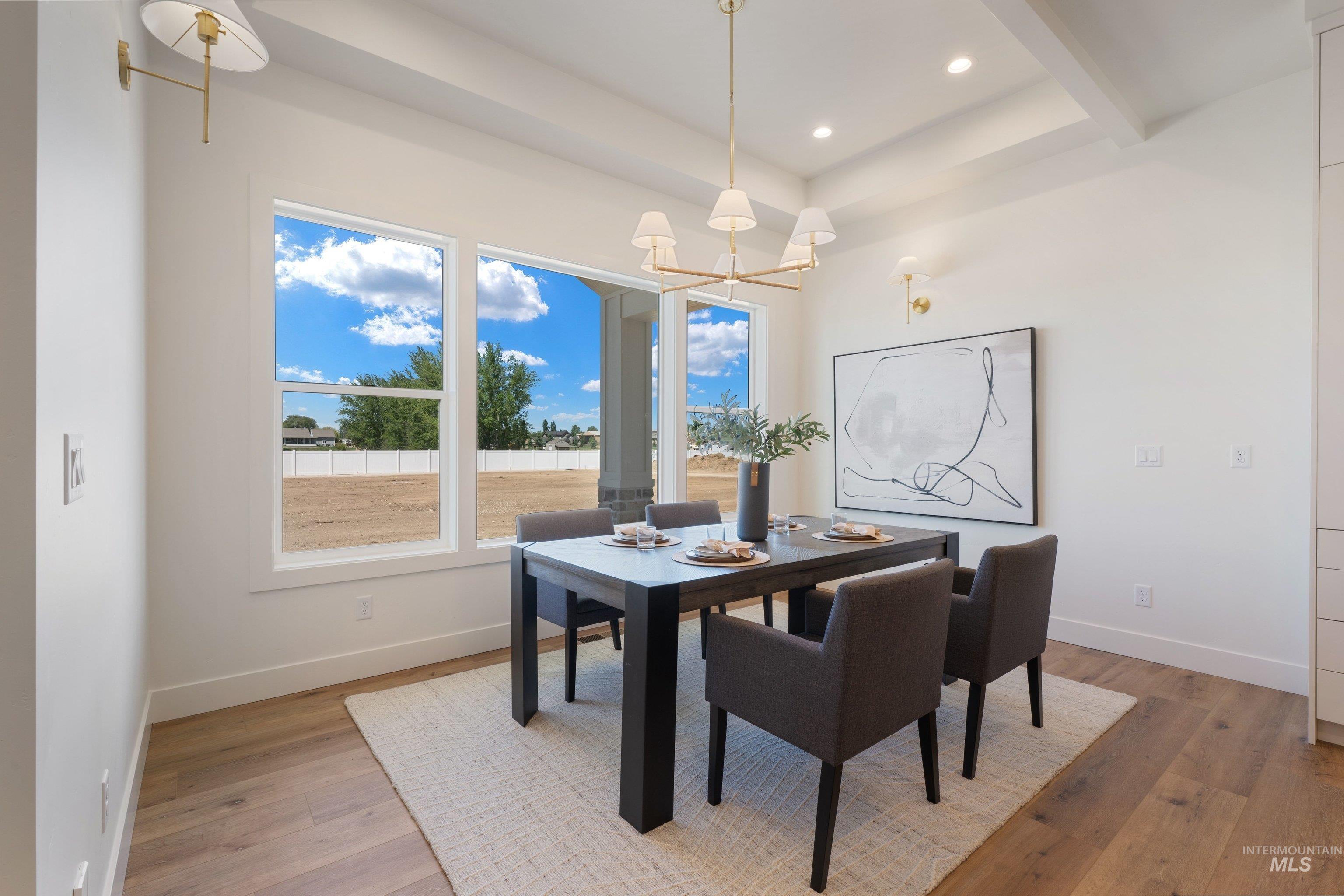 24821 Ardmore Court Caldwell, ID 83607 - Photo 22 of 43 Bright dining area featuring wood-finish flooring, a coffered ceiling, and a contemporary chandelier