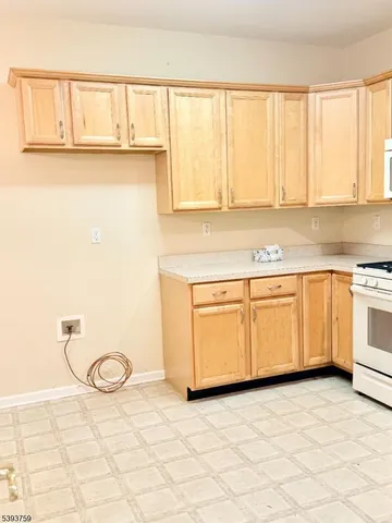 a kitchen with a stove a sink and white cabinets