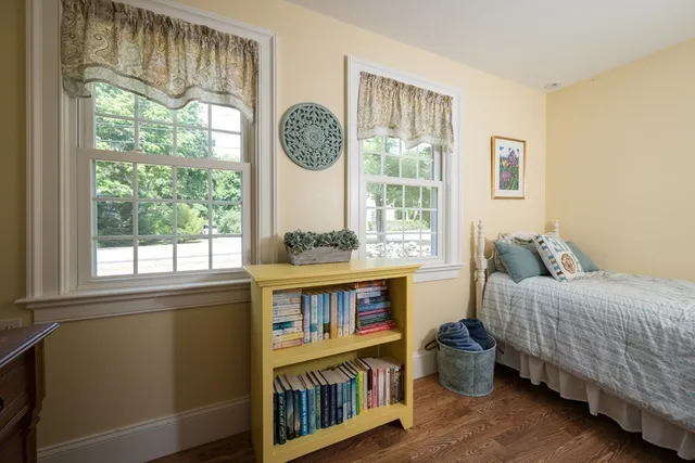 a bedroom with a bed and a large window