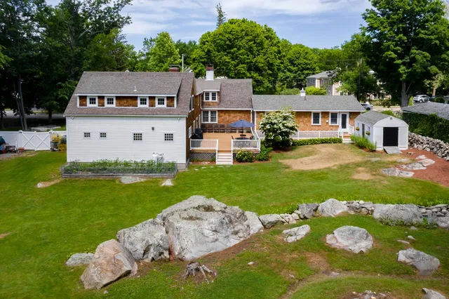 an aerial view of a house with backyard and a fountain