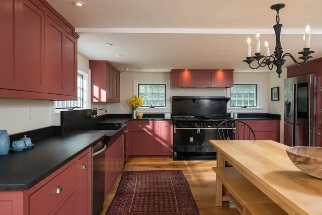 a kitchen with stainless steel appliances a stove top oven a sink a counter space and cabinets