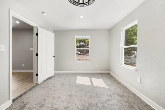 an empty room with windows and closet