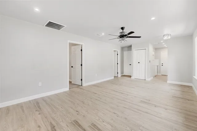 an empty room with fan and entrance