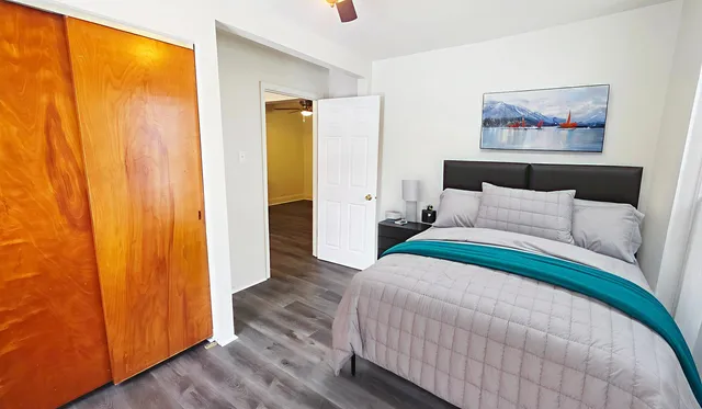 a bedroom with a bed and a painting on the wall