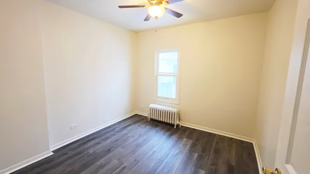 an empty room with a window and a ceiling fan