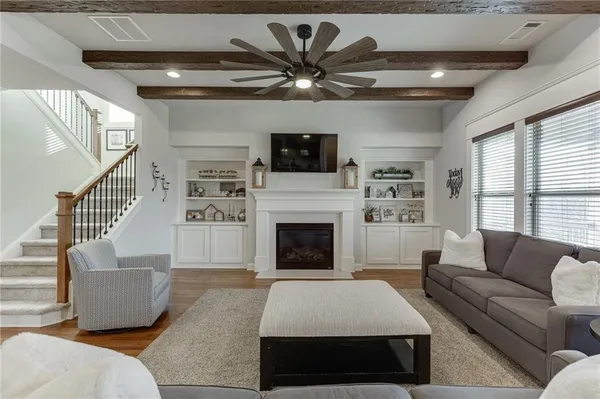 a living room with furniture kitchen area and a large window