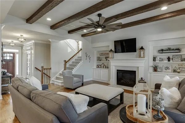 a living room with furniture kitchen view and a chandelier