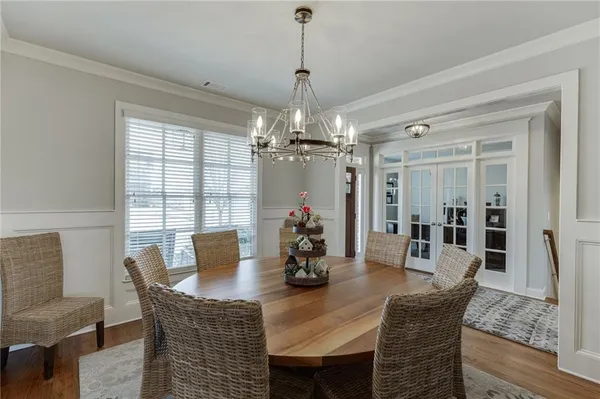 a dining room with furniture potted plants and wooden floor