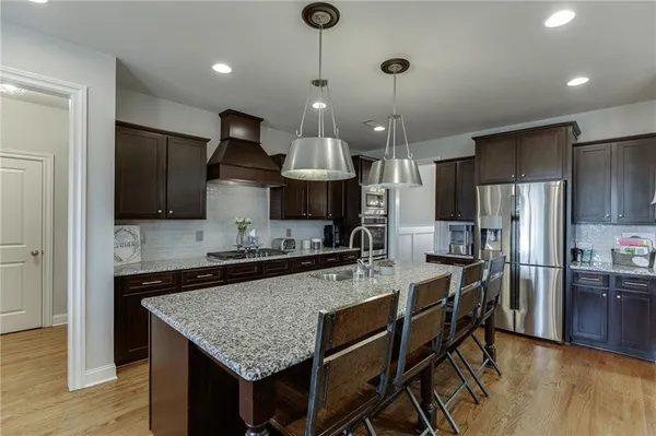 a kitchen with stainless steel appliances granite countertop a stove refrigerator a sink and a microwave