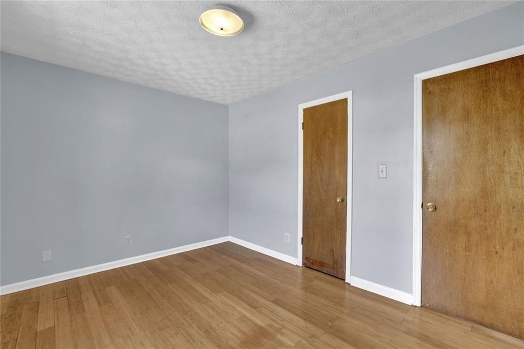 4341 Five Forks Trickum Road Southwest Lilburn, GA 30047 - Photo 12 of 35 a view of an empty room with wooden floor and a window