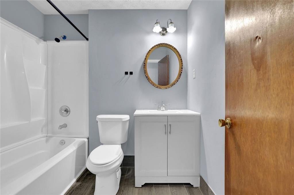 4341 Five Forks Trickum Road Southwest Lilburn, GA 30047 - Photo 15 of 35 a bathroom with a toilet sink and mirror